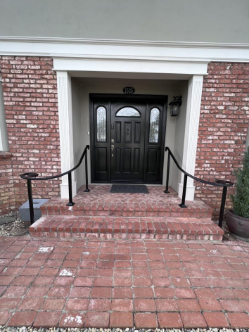 Entry stair handrails at a brick doorway